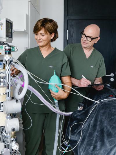 Mitarbeitende bei einer medizinischen Behandlung mit Anästhesiegerät in einem Behandlungsraum der Praxis